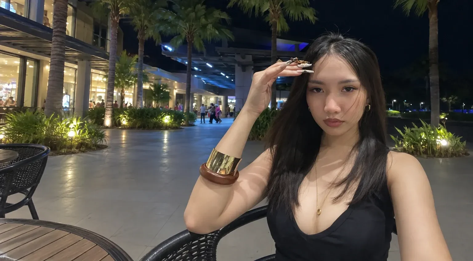 Riri seated outdoors at night